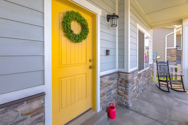 yellow front door with rocking chair