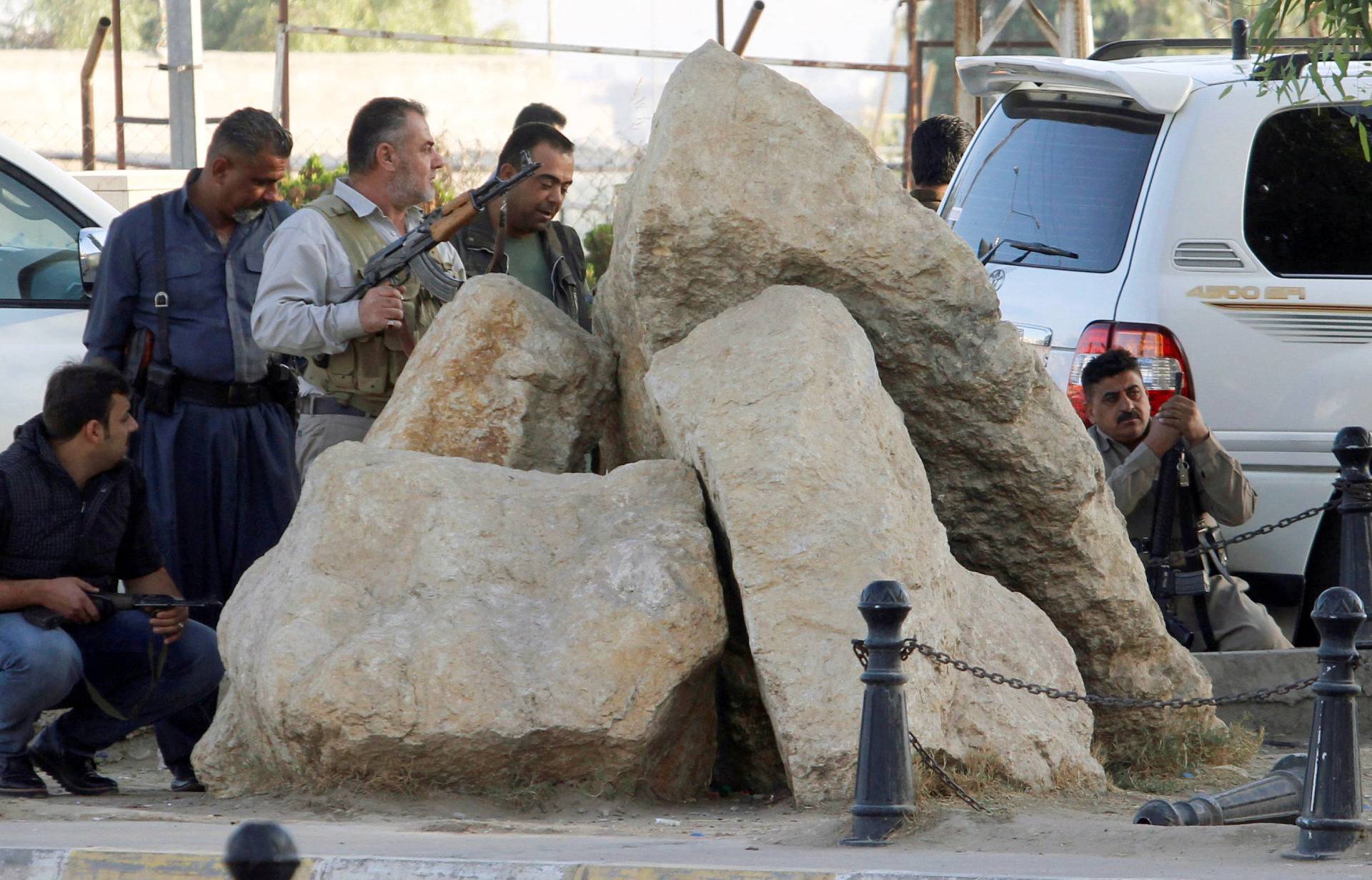 Peshmerga forces stand behind rocks at a site of an attack by Islamic State militants in Kirkuk