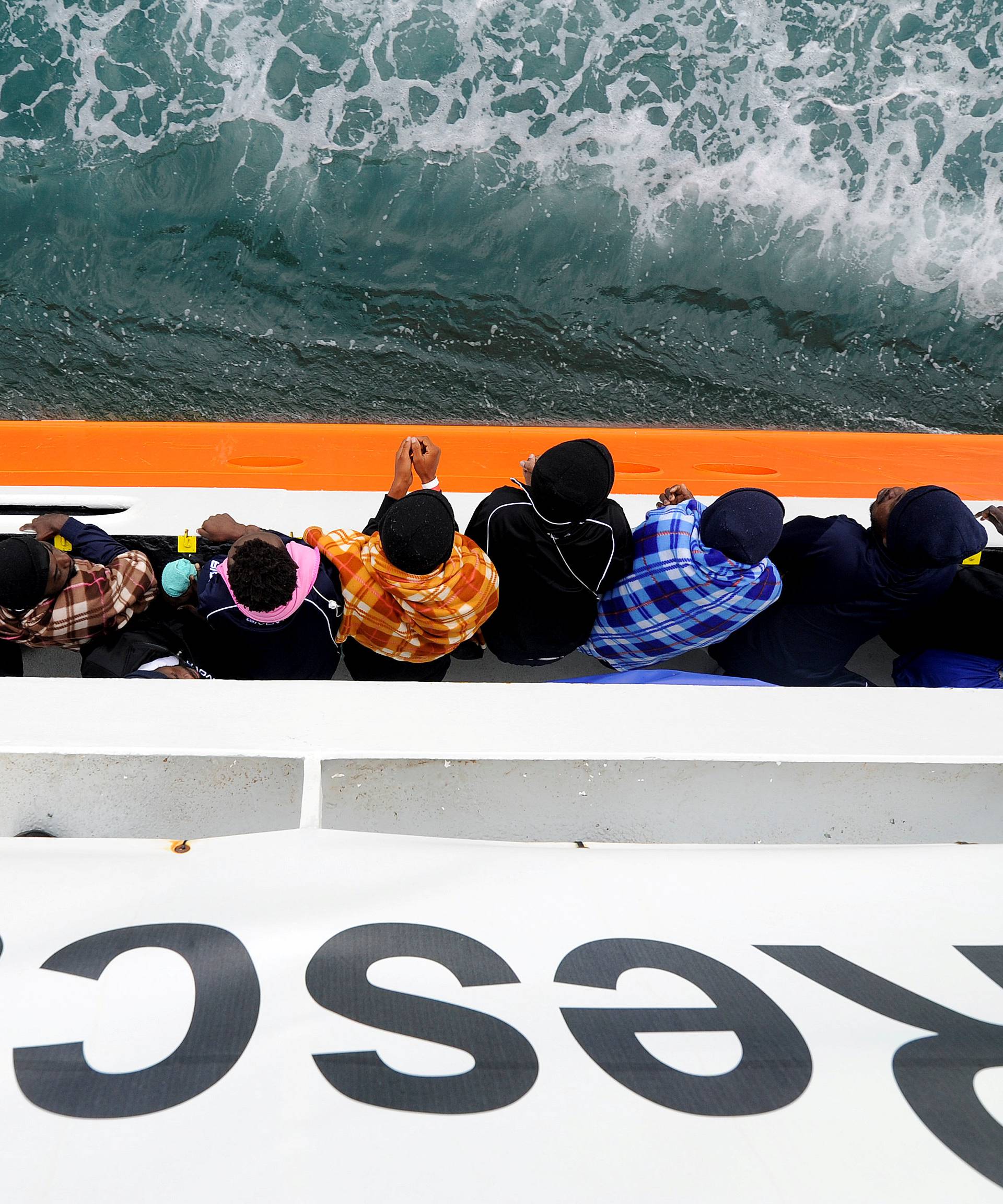 Migrants wait to disembark from Aquarius in the Sicilian harbour of Catania
