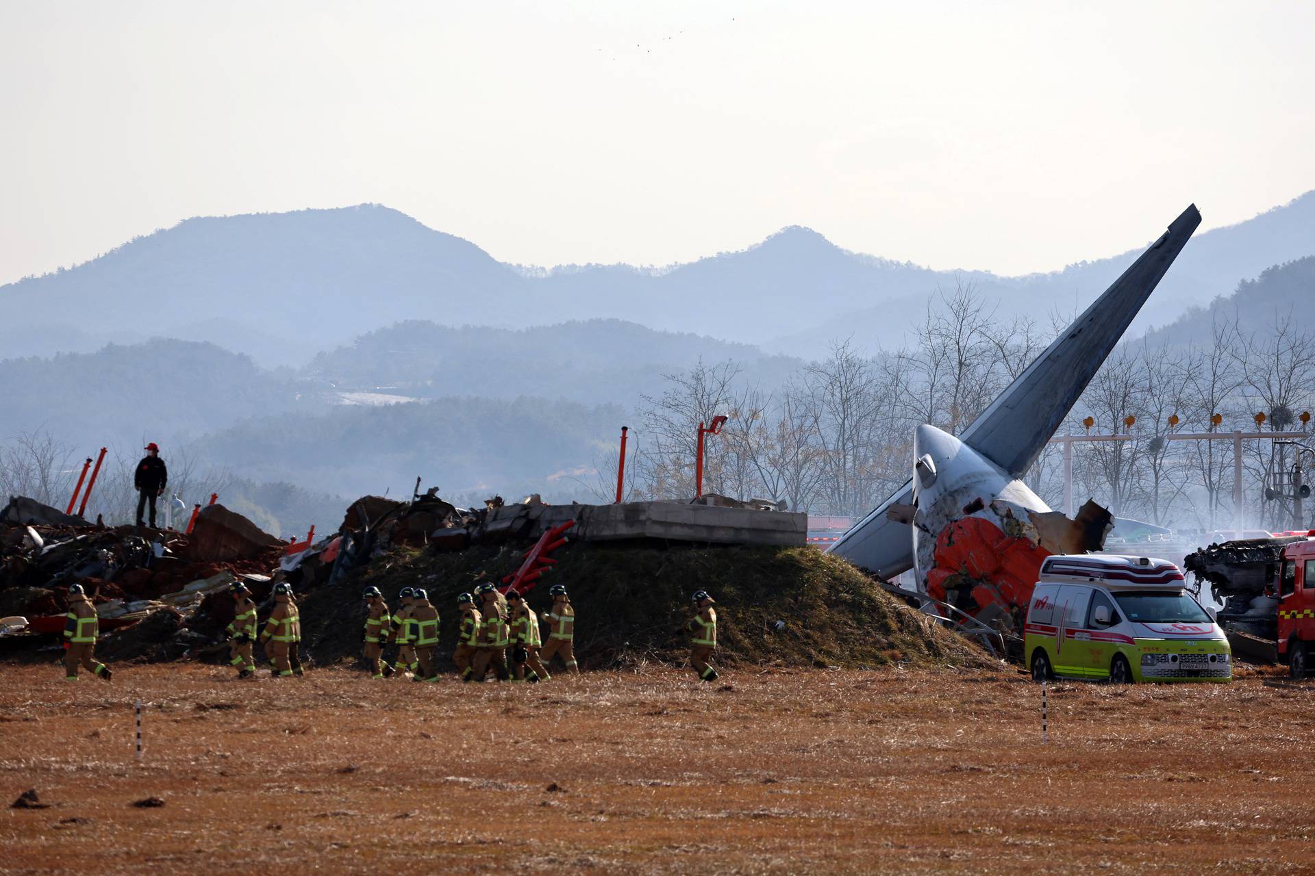 Firefighters carry out rescue operations on an aircraft which drove off the runway at Muan International Airport in Muan