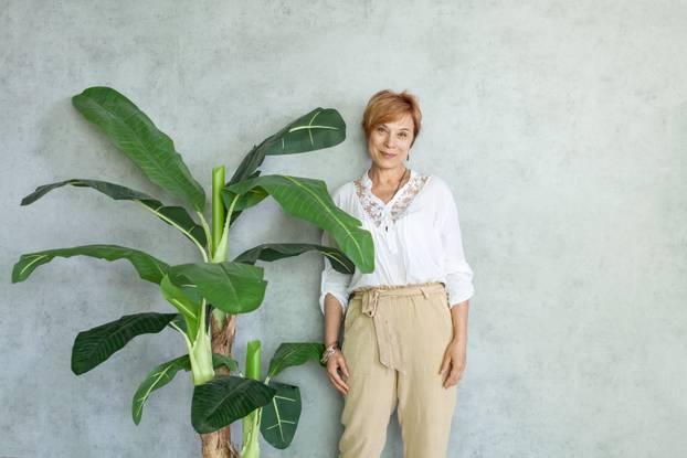 Cute successful woman smiling on gray background indoor