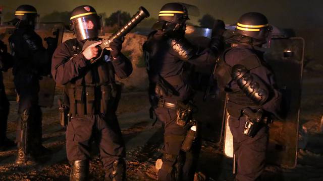 French CRS riot police secure an area on the eve of the evacuation and transfer of migrants to reception centers in France, and the dismantlement of the camp called the "Jungle" in Calais