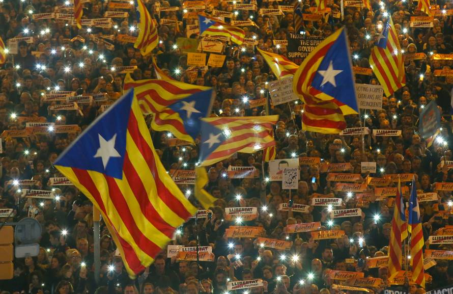 Protesters hold the lights of their mobile phones as they wave Estelada flags during a demonstration called by pro-independence associations asking for the release of jailed Catalan activists and leaders, in Barcelona