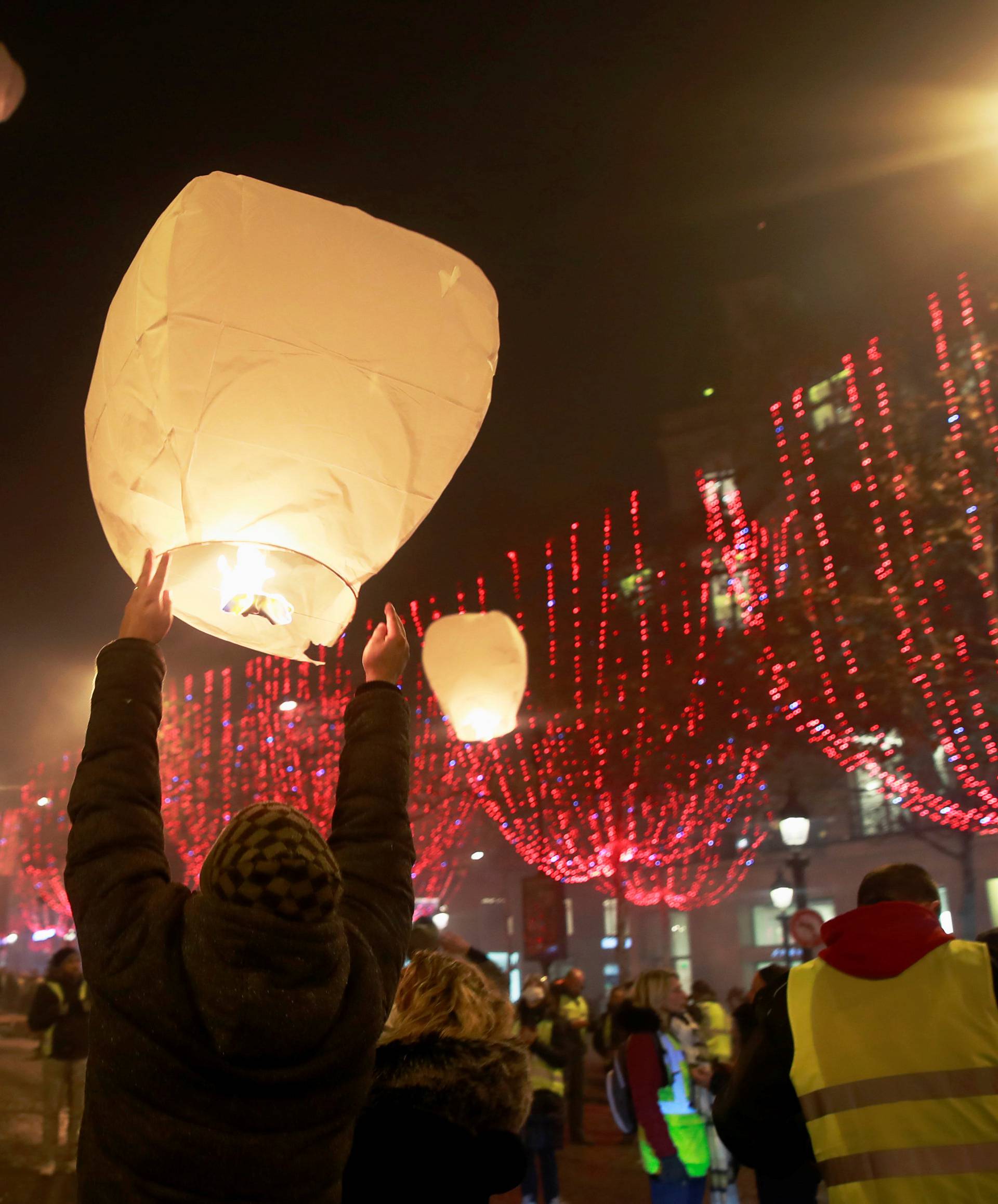 A man releases a paper lantern during a "Yellow vest" protest against higher fuel prices, on the Champs-Elysees in Paris