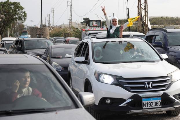 Displaced people cross the bridge linking southern Lebanon to the rest of the country, which was hit earlier in an Israeli strike, in Qasmiyeh