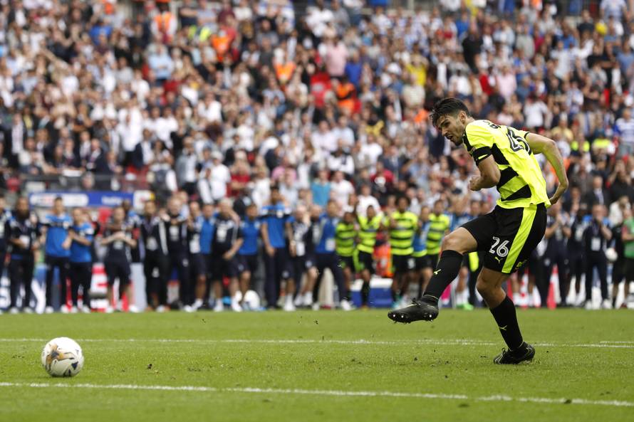 Huddersfield Town's Christopher Schindler scores a penalty to win the penalty shootout and get promoted to the Premier League