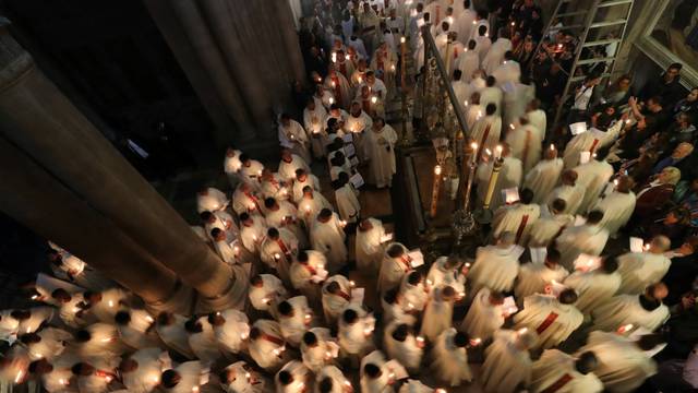 Worshippers take part in a procession during the Catholic Washing of the Feet ceremony on Easter Holy Week in the Church of the Holy Sepulchre in Jerusalem's Old City