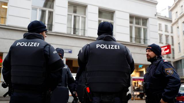 Police officers secure the area after shots were fired in a restaurant in downtown Vienna