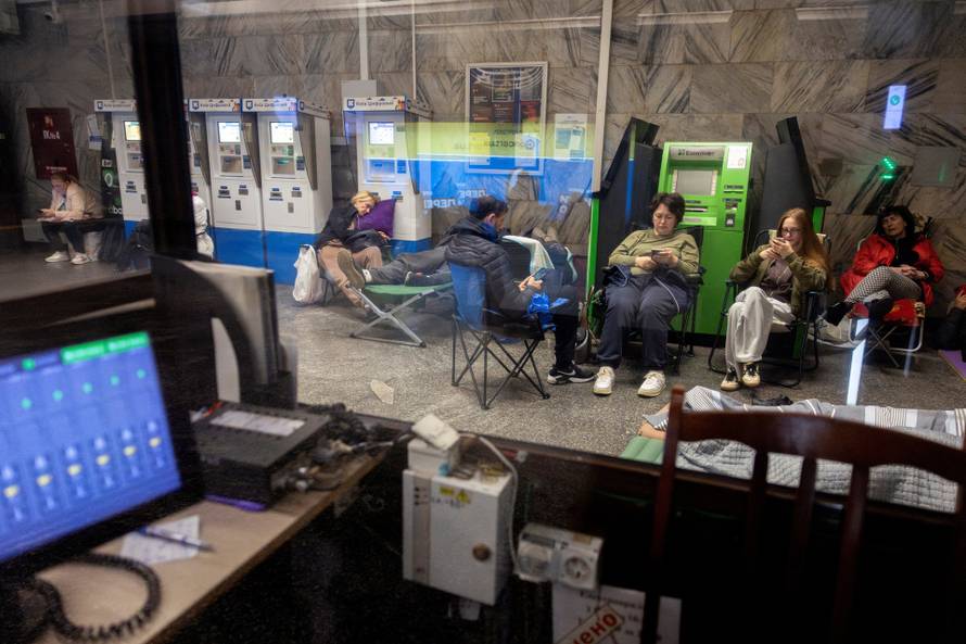 People take shelter in a metro station during a Russian drone attack in Kyiv