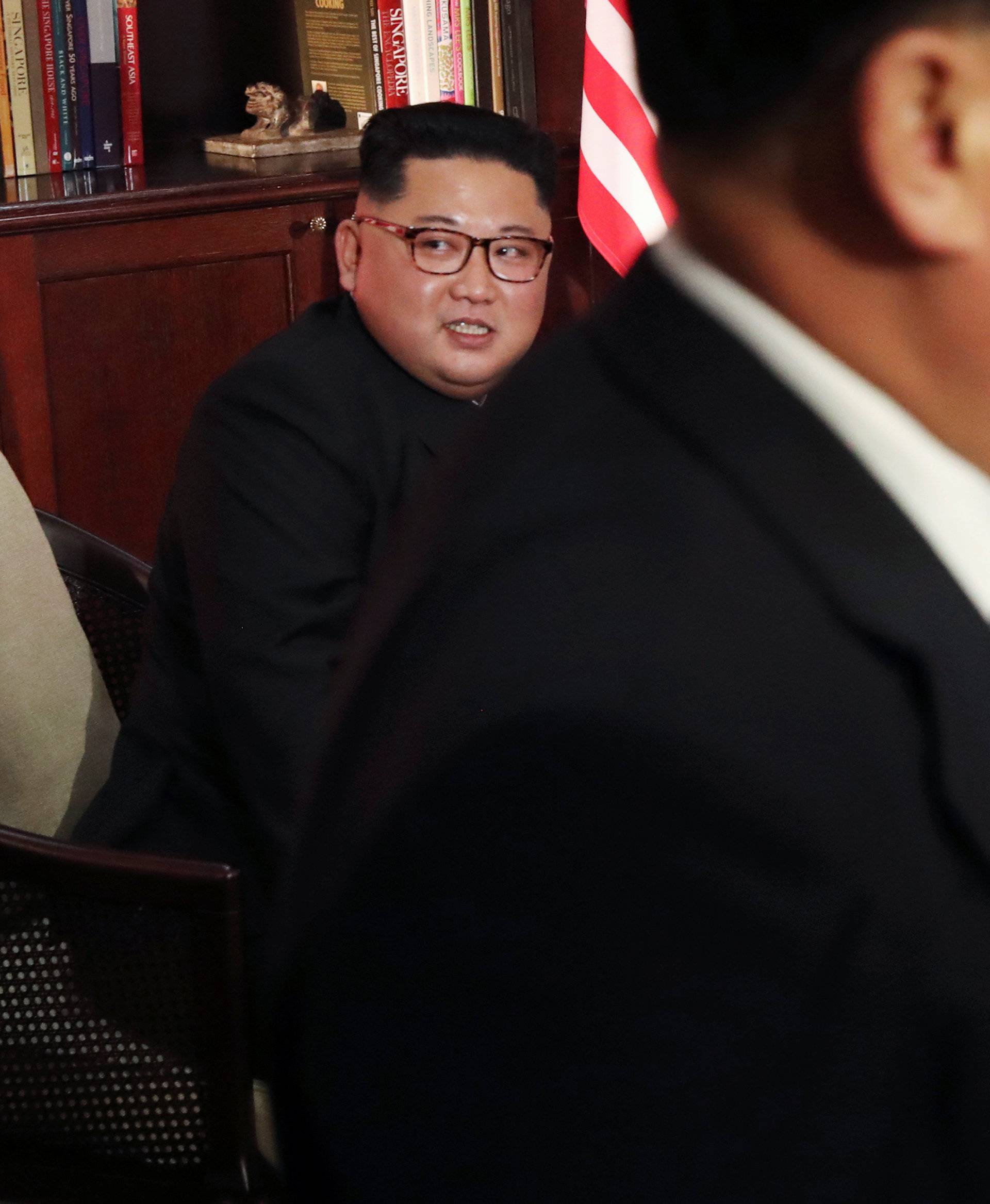 U.S. President Donald Trump sits next to North Korea's leader Kim Jong Un before their meeting in Singapore