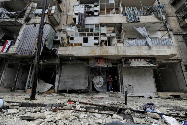 Boys stand amid the damage in the governemnt-held al-Shaar neighborhood of Aleppo