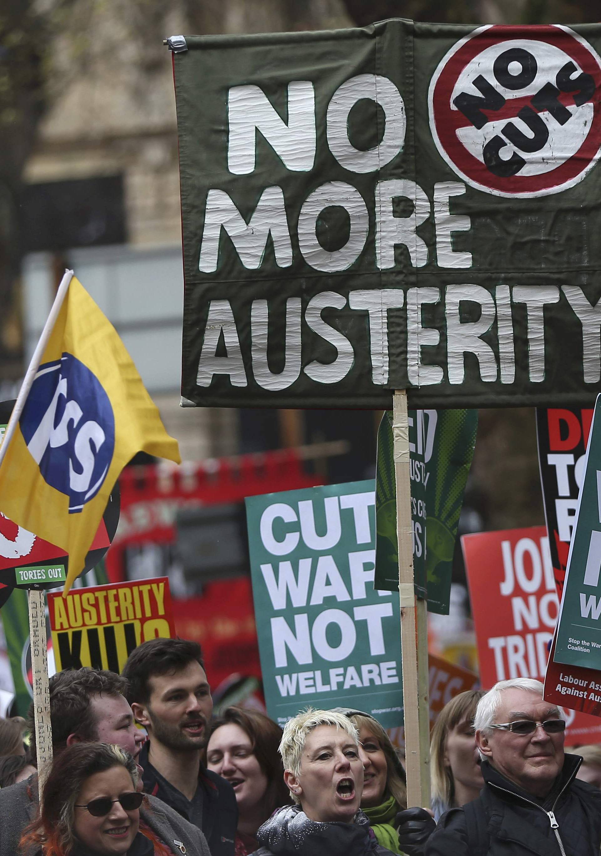 Demonstrators hold placards during an anti-austerity protest in London