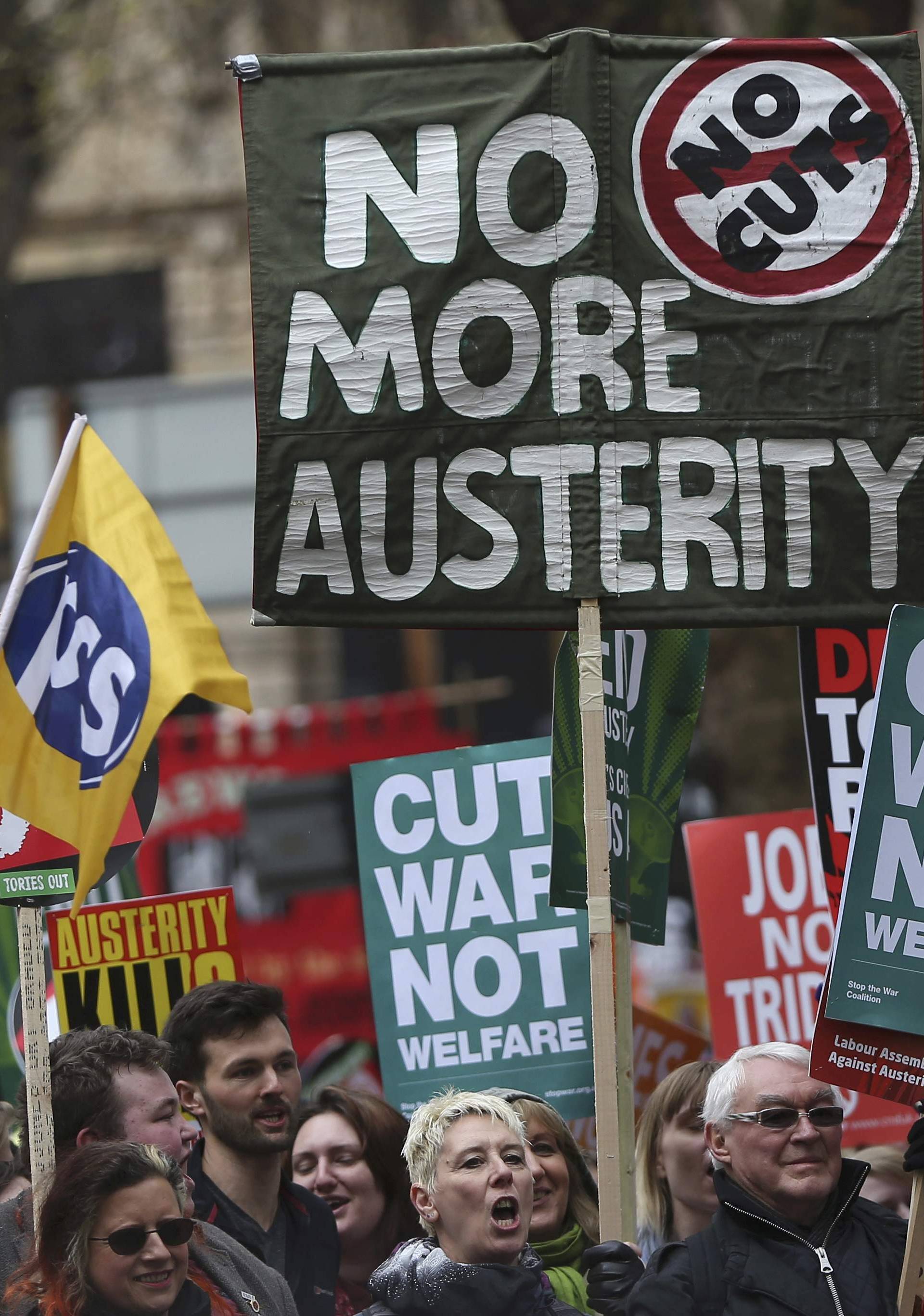 Demonstrators hold placards during an anti-austerity protest in London