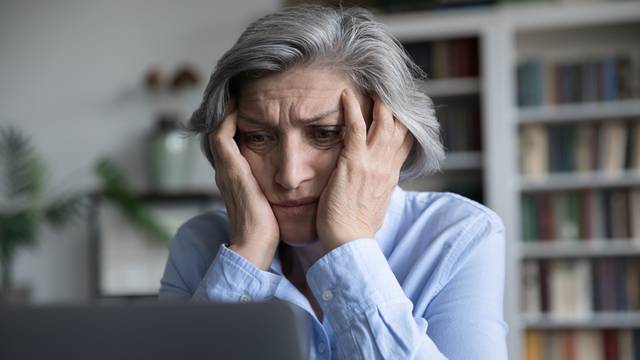 Frustrated,Senior,Retired,Woman,Touching,Head,,Looking,At,Laptop,Screen