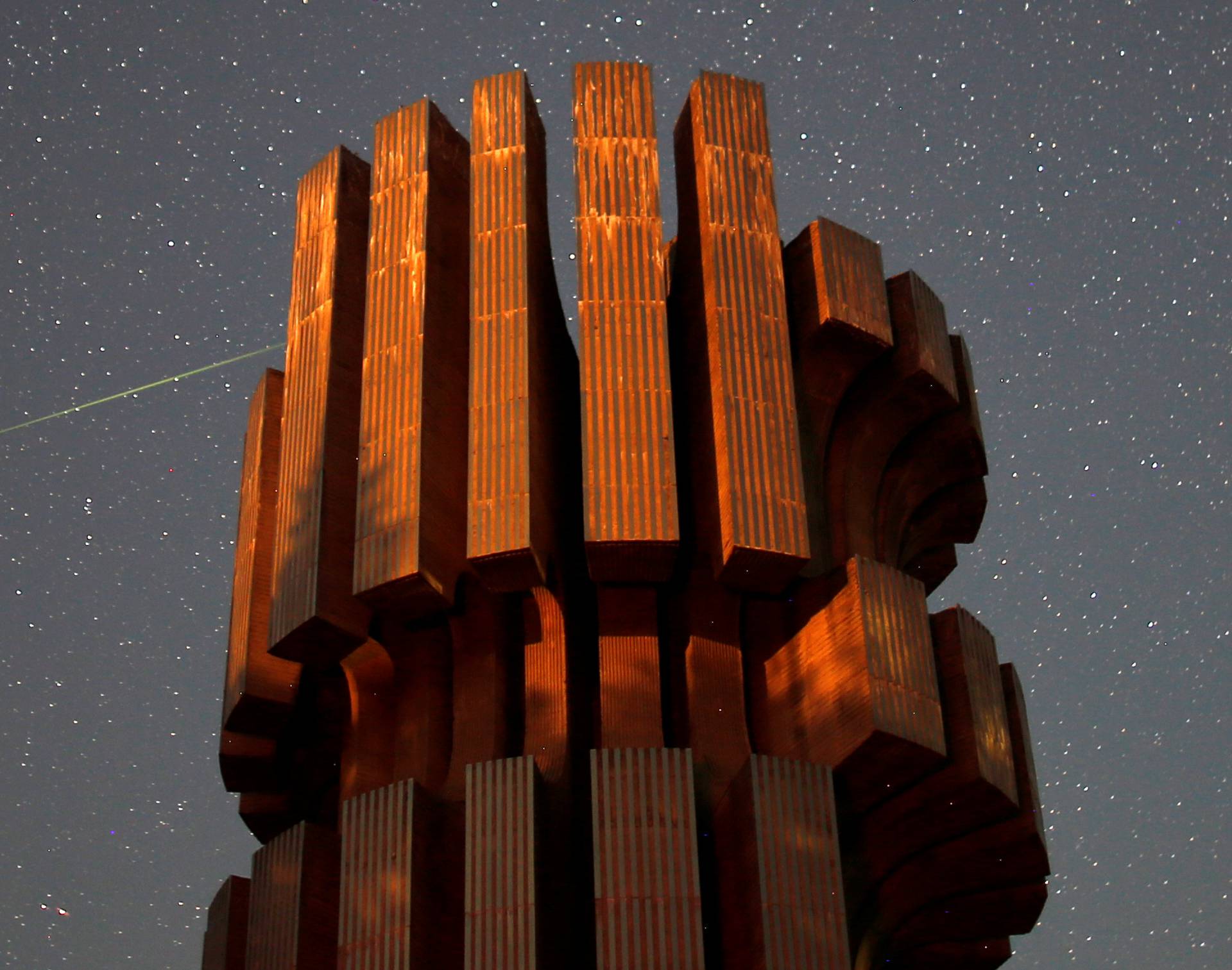 Meteor streaks across skies near the Monument to the Revolution in Prijedor