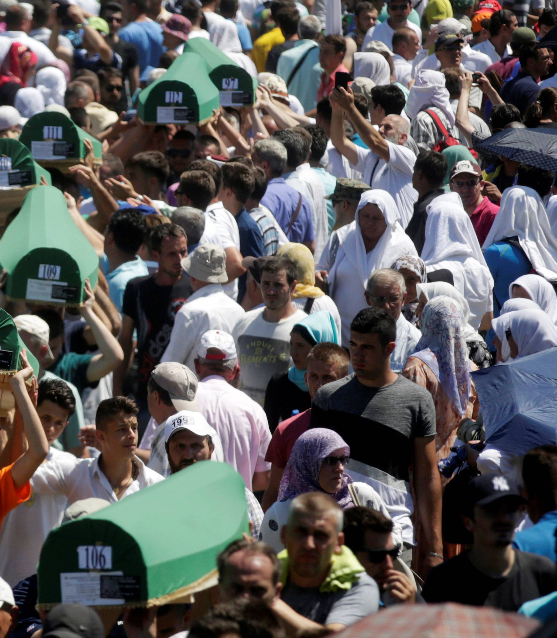 Muslim men carry coffins of their relatives, who are newly identified victims of the 1995 Srebrenica massacre, during mass funeral in Potocari near Srebrenica