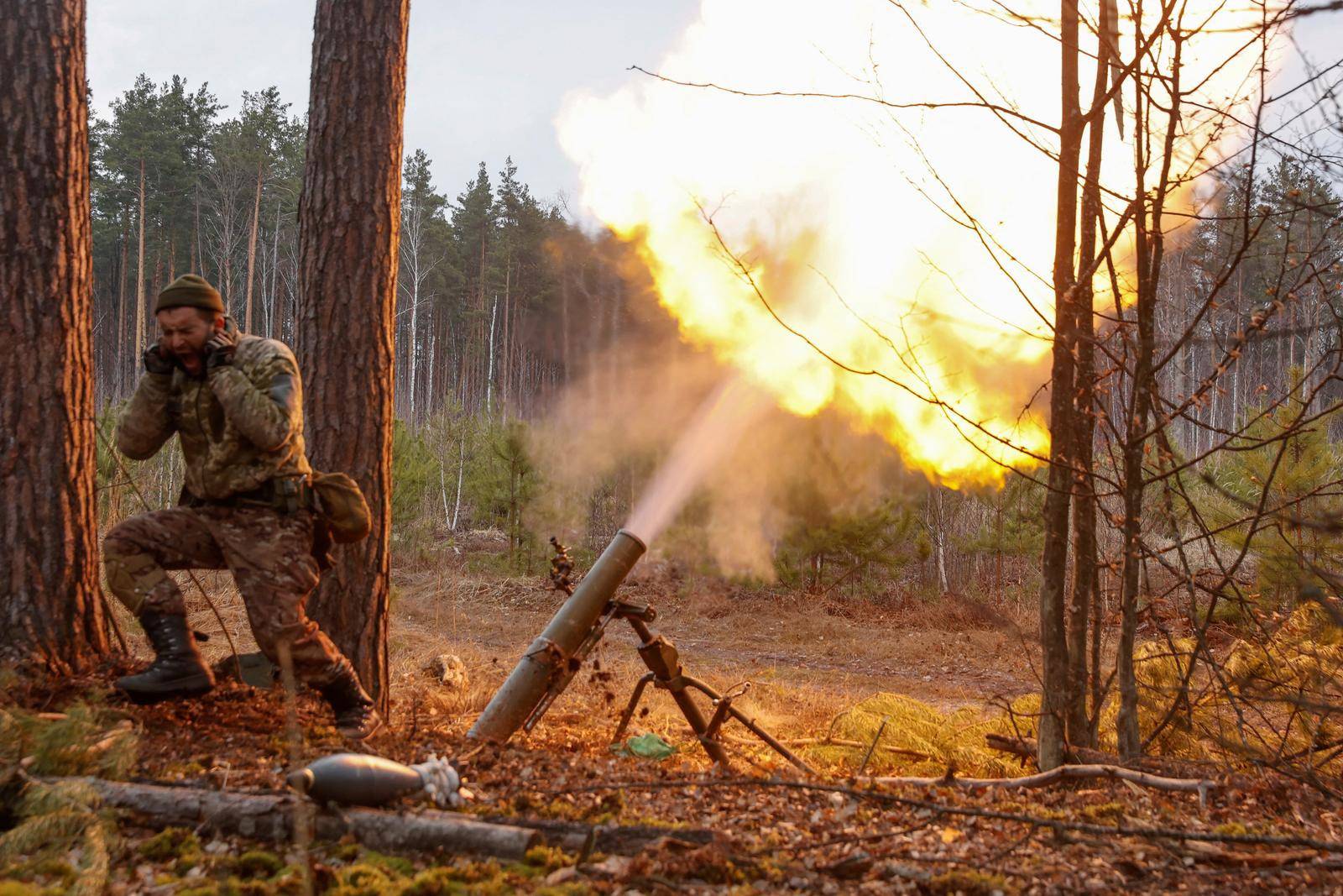 A Ukrainian serviceman fires with a mortar in Kyiv region