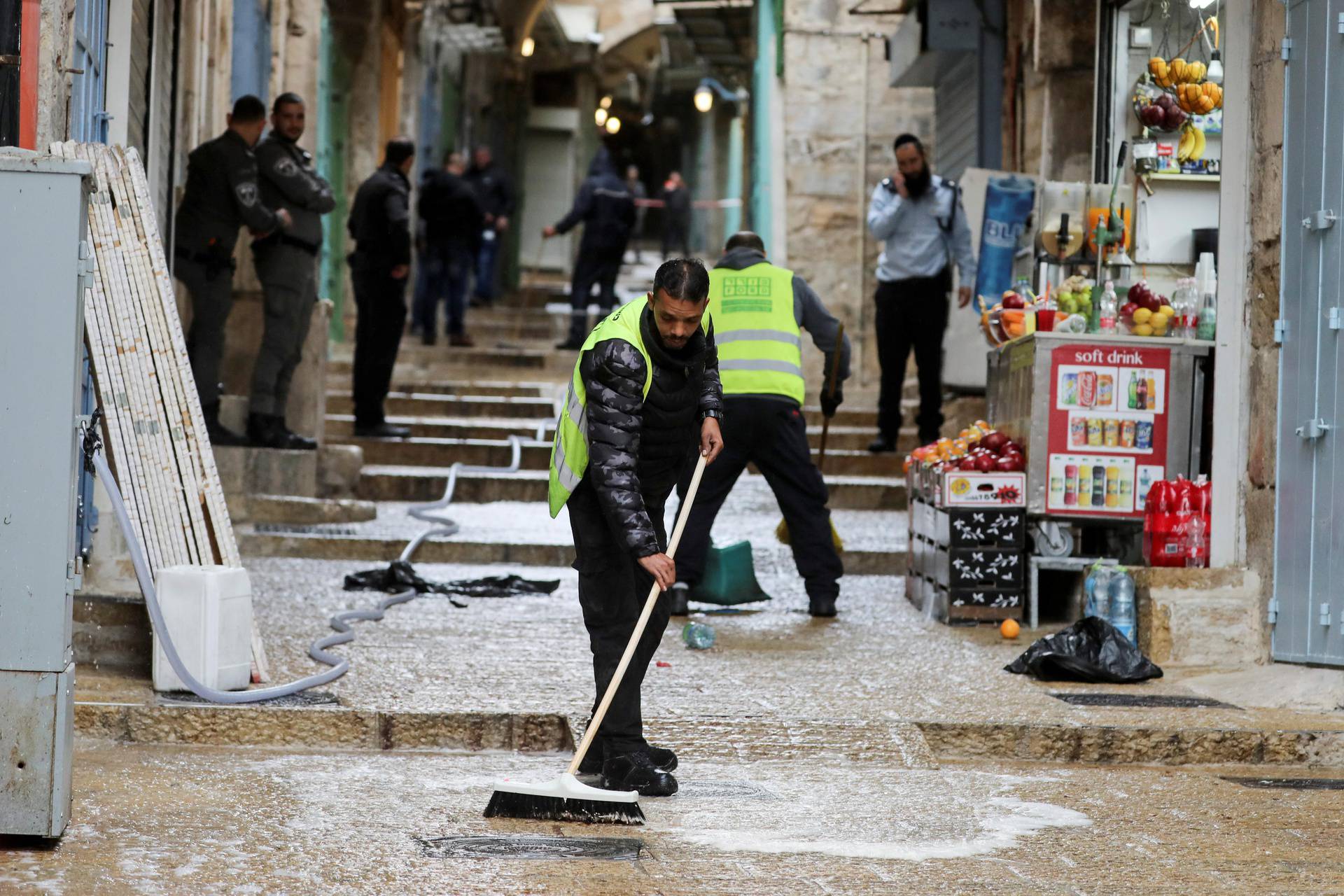 Workers clean the stairs at the site of a shooting incident in Jerusalem's Old City