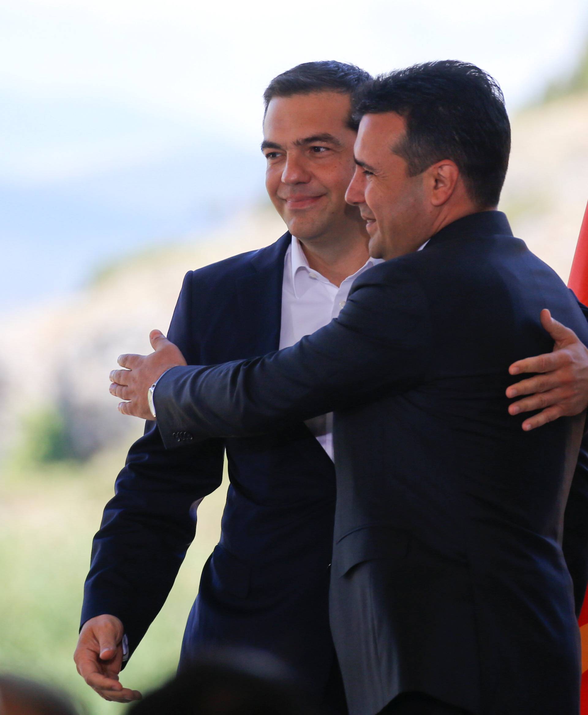 Greek Prime Minister Alexis Tsipras and Macedonian Prime Minister Zoran Zaev hug before the signing of an accord to settle a long dispute over the former Yugoslav republic's name in the village of Psarades