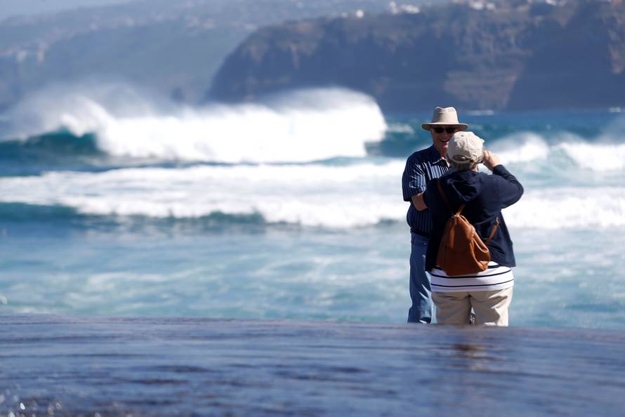 Tourists take photos in Martianez beach on the island of Tenerife in Spain's Canary Islands