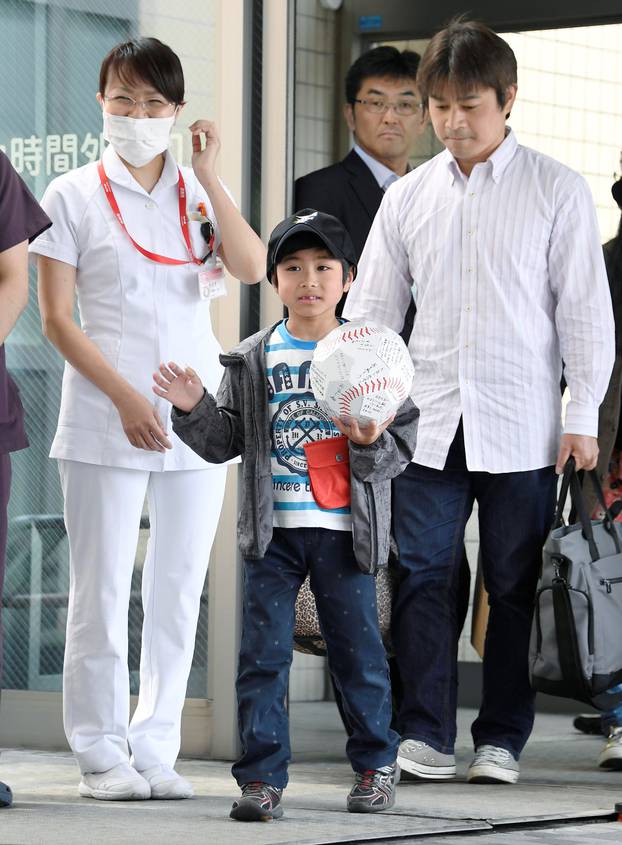 Yamato Tanooka, who was found by authorities in the woods nearly a week after his parents abandoned him for disciplinary reasons, waves as he leaves a hospital with his father Takayuki in Hakodate