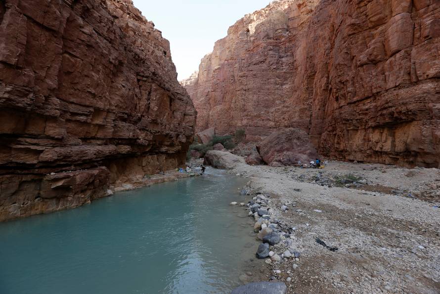 People swim in a river in the Valley of al-Zara, which flows into the Dead Sea, in Jordan