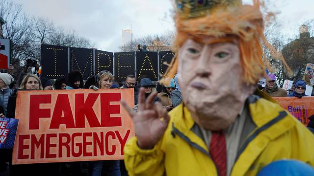 Protesters hold signs during a demonstration against U.S. President Donald Trump on Presidents' Day in Union Square, New York