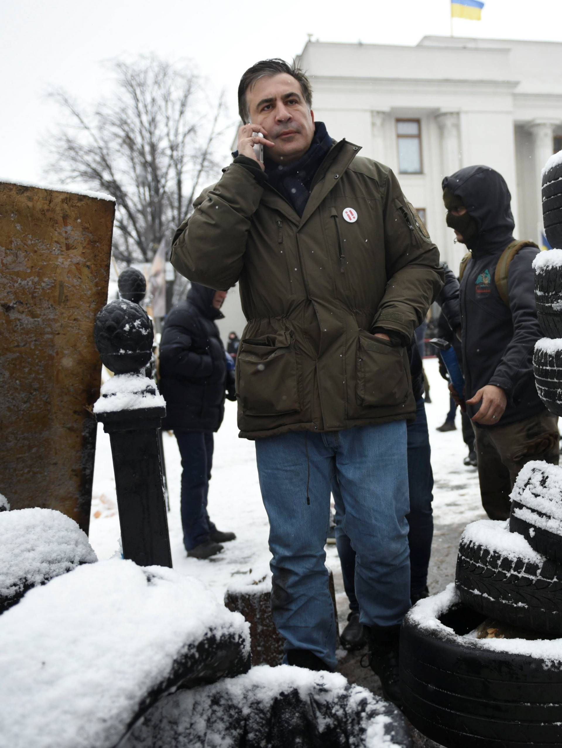 Former Georgian President Mikheil Saakashvili speaks on the phone in front of the Parliament building in Kiev