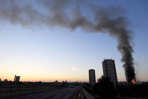 The A40 road is seen closed as flames and smoke billow as firefighters deal with a serious fire in a tower block at Latimer Road in West London