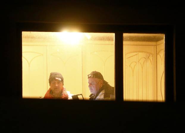 Crime scene investigators are seen through the window of a house where six people were found dead in Boeheimkirchen