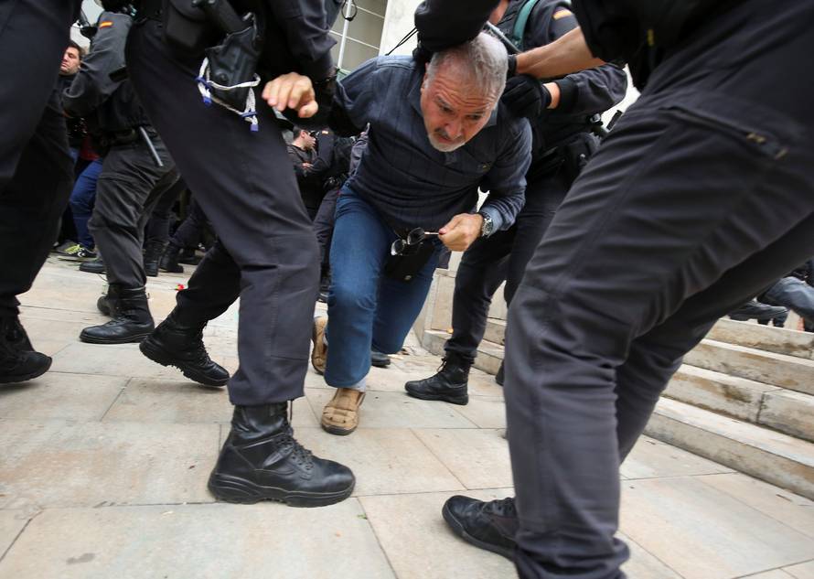 Man is dragged away by officers outside polling station for Catalonia referendum in Sant Julia de Ramis