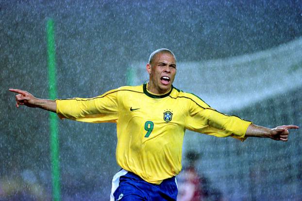 FILE PHOTO: Brazil striker Ronaldo celebrates in the heavy rain after scoring against Barcelona in a 2-2 draw during a rare friendly match between a national team and a club