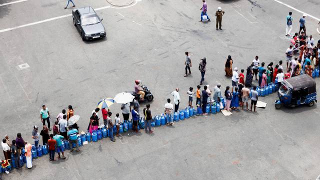 People block a main road as they wait for the gas trucks to arrive, in Colombo