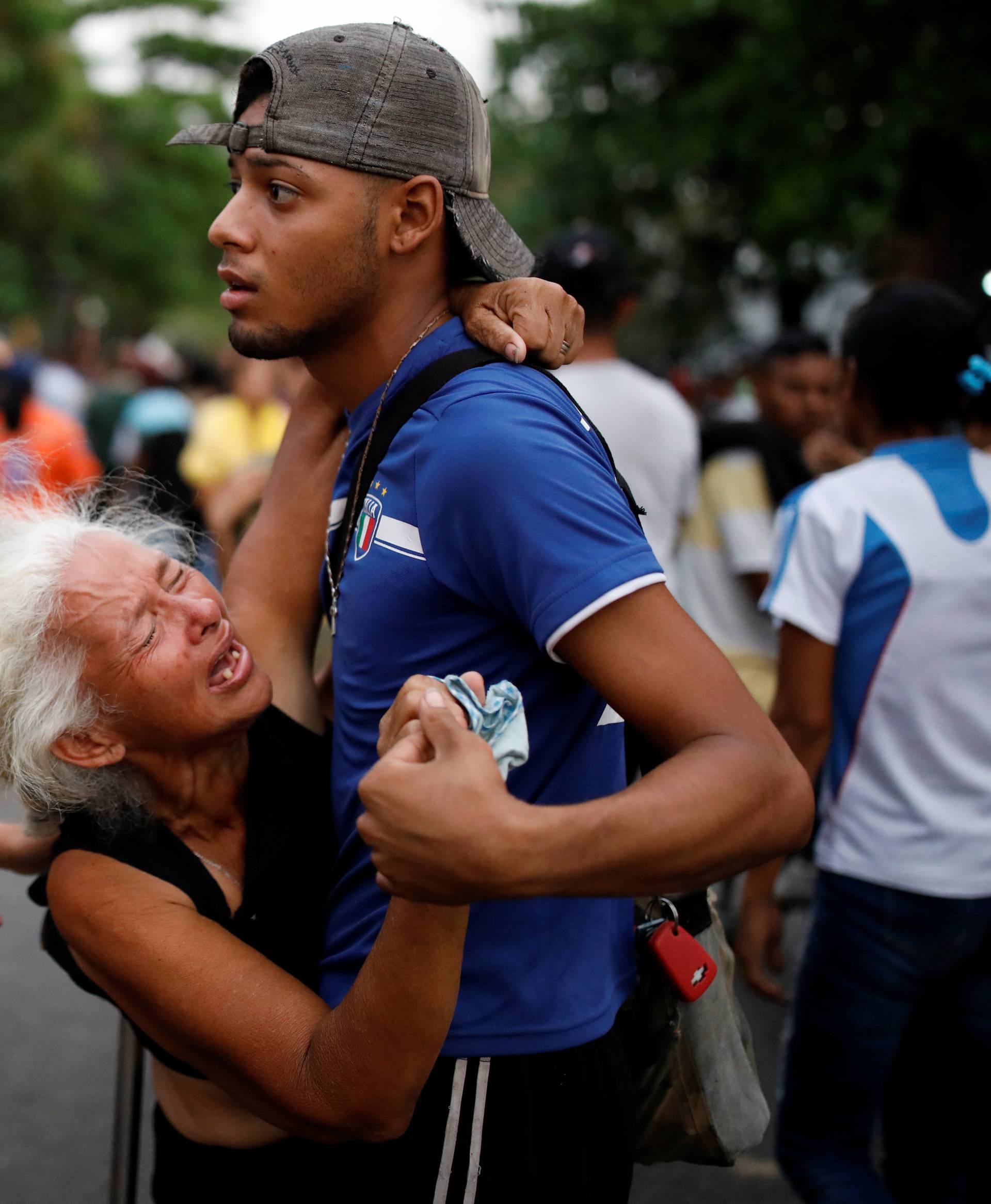 Relatives of inmates held at the General Command of the Carabobo Police react as they wait outside the prison where a fire occurred in Valencia
