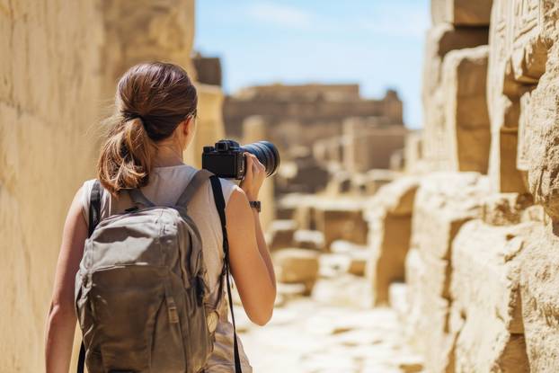Exploring ancient ruins with a camera in a sunlit archaeological site