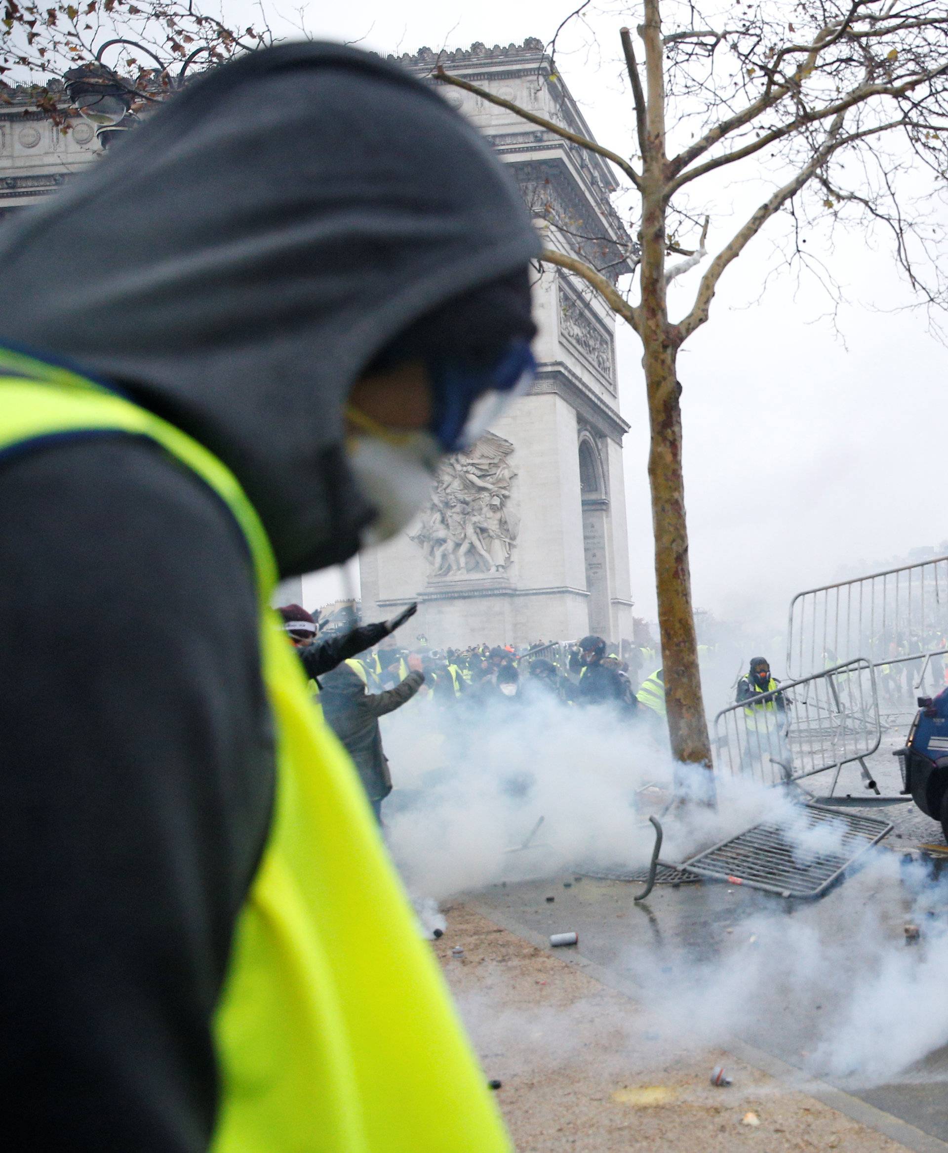 Protesters wearing yellow vests, a symbol of a French drivers' protest against higher diesel taxes, face off with French gendarmes during clashes at the Place de l'Etoile near the Arc de Triomphe in Paris