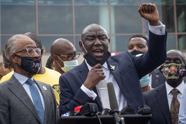 Attorney Ben Crump raises his arm while addressing media during the public viewing for Floyd at The Fountain of Praise church in Houston