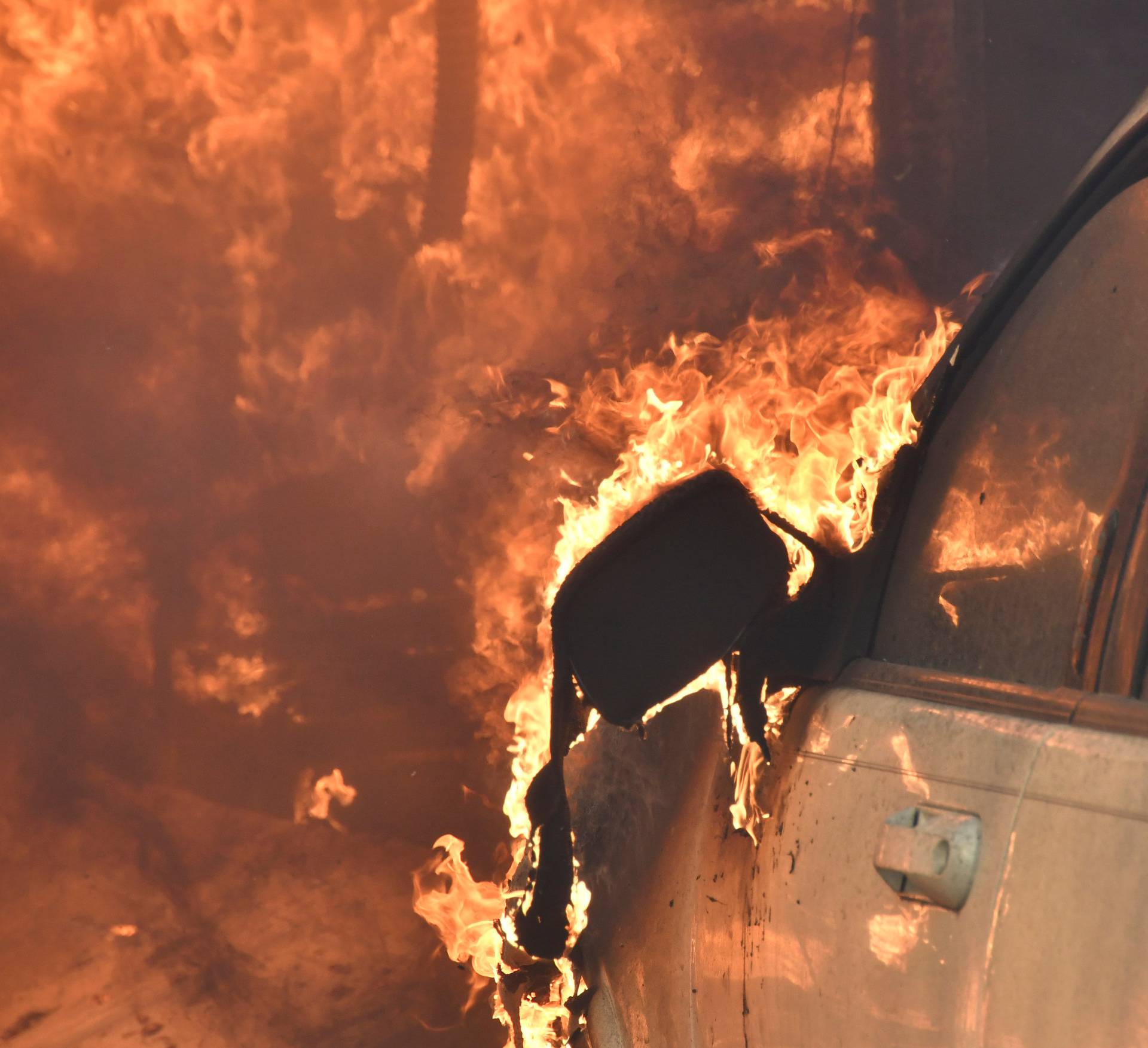 A car burns in front of one of many home destroyed by an early-morning Creek Fire that broke out in the Kagel Canyon area in the San Fernando Valley north of Los Angeles