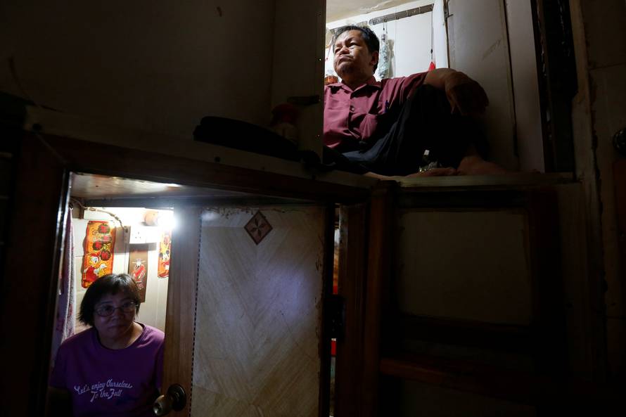 Unemployed Hong Kong residents Lam, 60, and Kitty Au, 63, rest inside their upper and lower decks partitioned units, or "coffin units", in Hong Kong