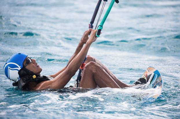 Former U.S. President Barack Obama tries his hand at kite surfing during a holiday with British businessman Richard Branson on his island Moskito, in the British Virgin Islands, in a picture handed out by Virgin