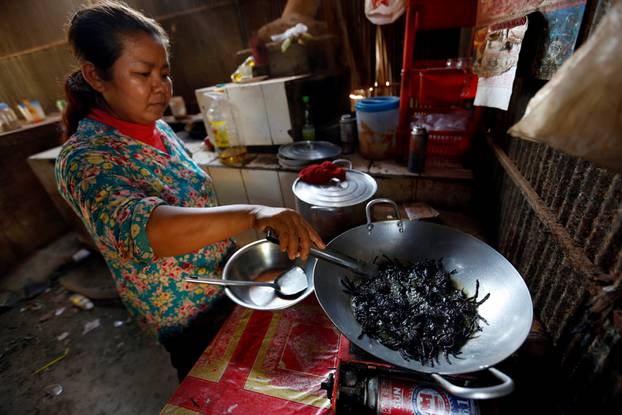 A woman fries tarantulas at her home in Kampong Cham province in Cambodia