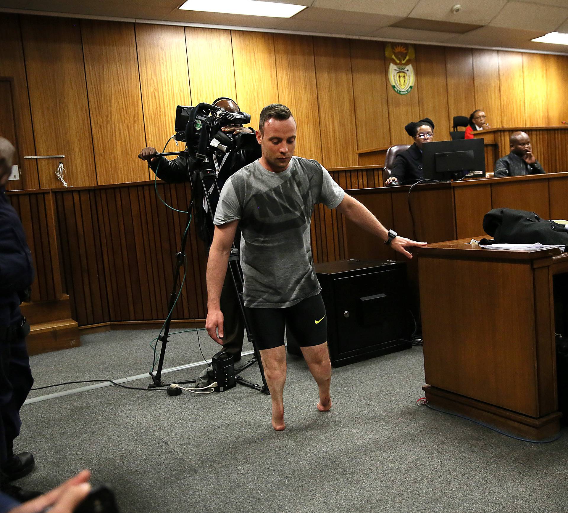 Paralympic gold medalist Oscar Pistorius walks across the courtroom without his prosthetic legs during the third day of his resentencing hearing for the 2013 murder of his girlfriend Reeva Steenkamp