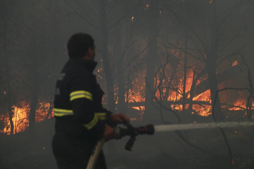 A firefighter tries to extinguish a wildfire in the village of Mravince near Split