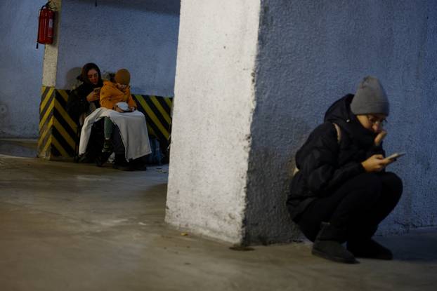 People take shelter inside an underground parking lot during a Russian missile and drone attack in Kyiv