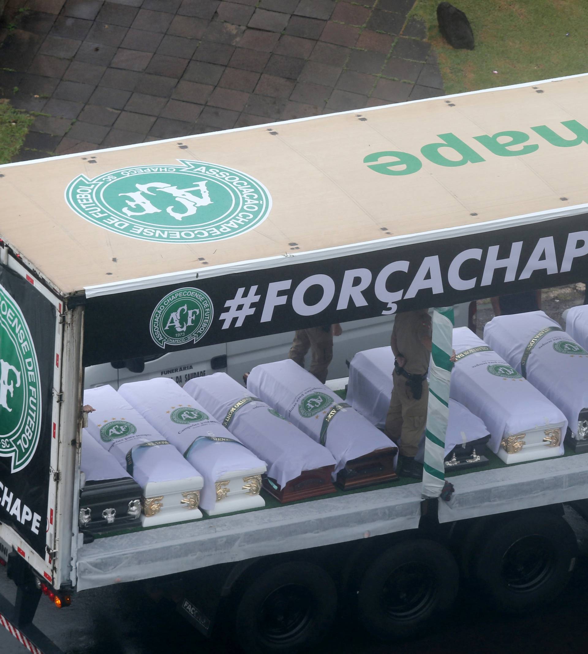 Coffins containing the remains of the victims  of the plane crash in Colombia are loaded in a truck after paying tribute to them at Arena Conda stadium in Chapeco