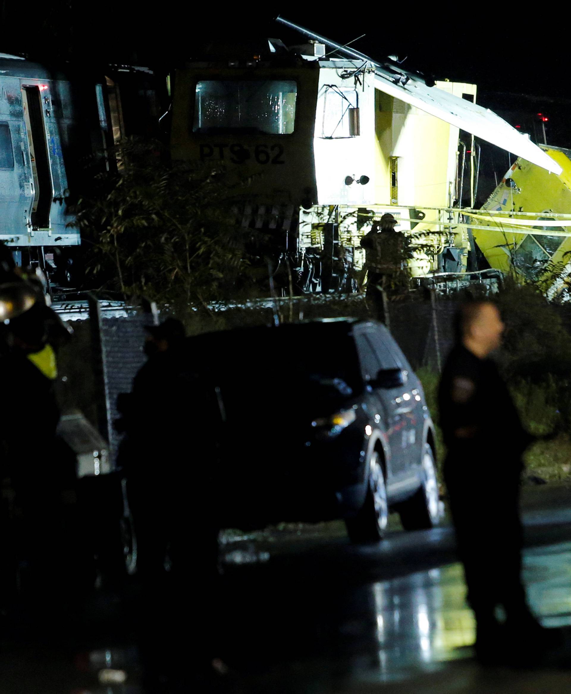 Emergency responders work near a train that sits derailed near the community of New Hyde Park on Long Island in New York