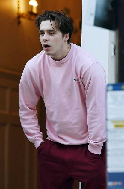 *EXCLUSIVE* WEB MUST CALL FOR PRICING  - David and Victoria Beckham's oldest son, Brooklyn Beckham is pictured spitting on a public street and grimacing in pain while seen wearing a bright pink jumper after visiting the dentist in London.