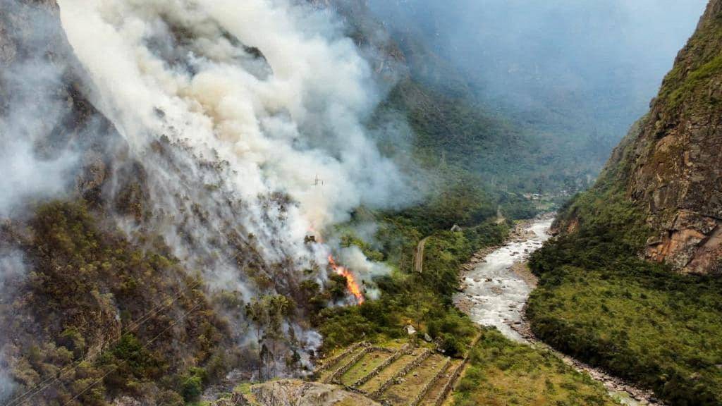 Emergency personnel work to put out a forest fire in Machu Picchu