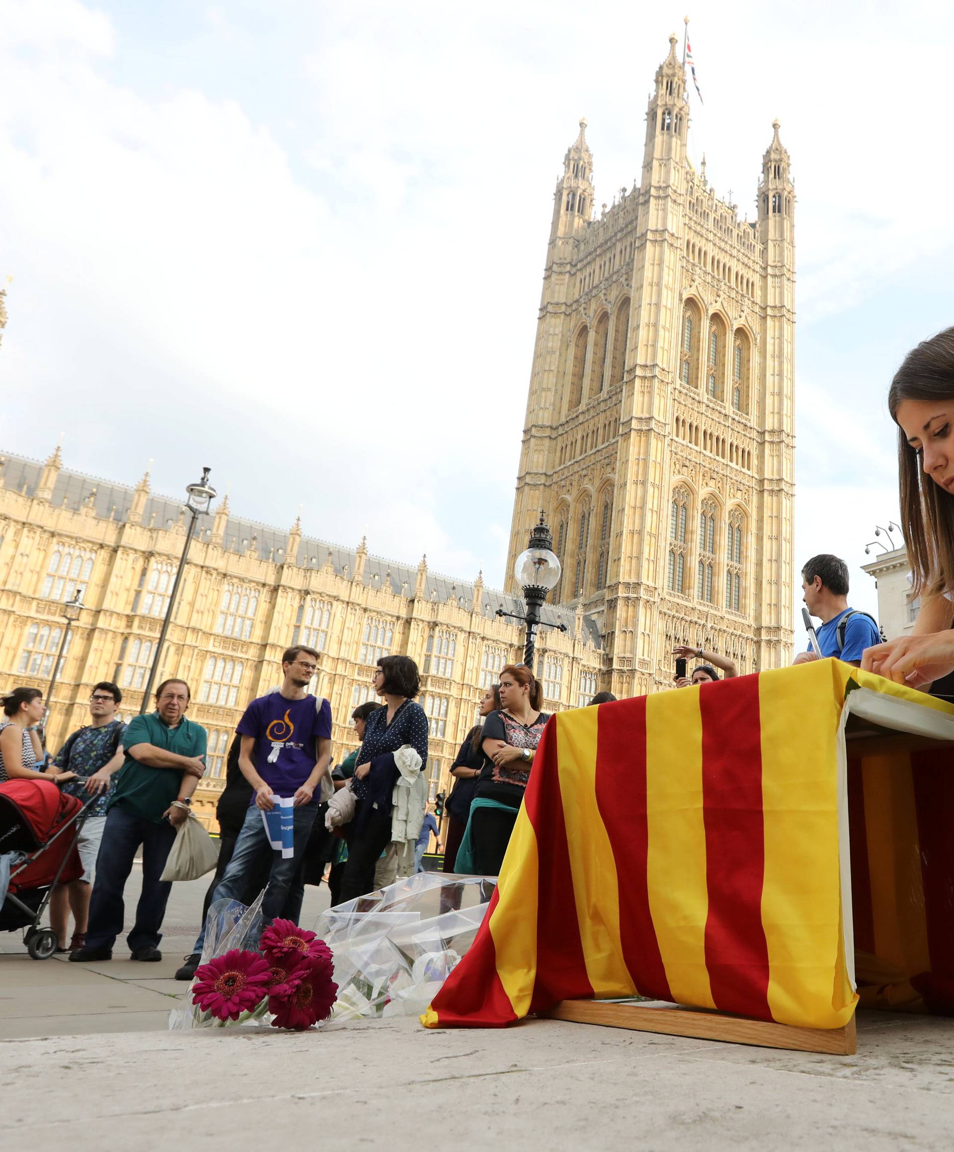 Woman signs a book of condolences during an event organised by members of the Catalan community in London