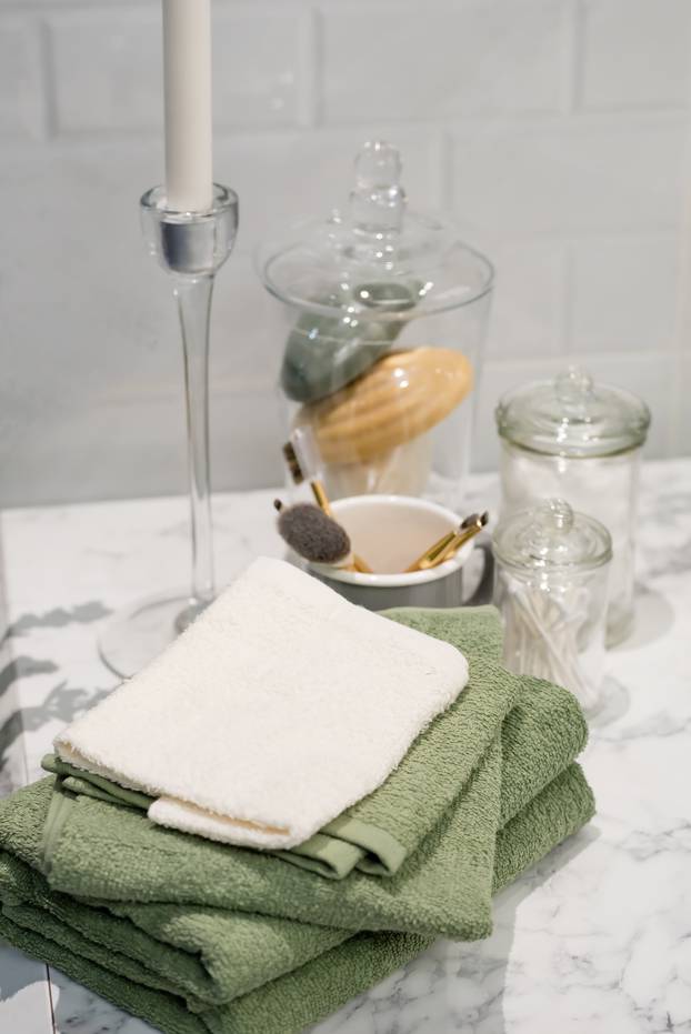 folded cotton towel under white marble bathroom marble counter